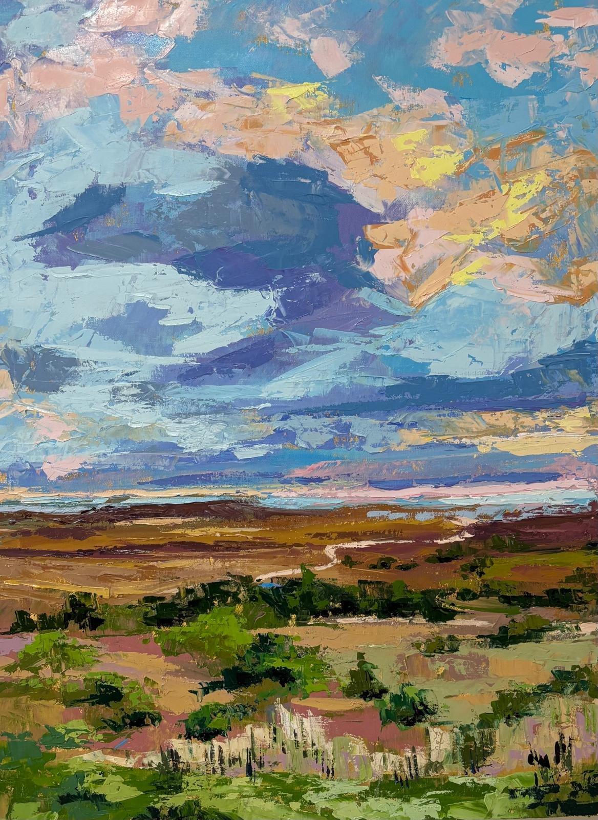 Paisaje de campo de tierra con un camino al fondo que llega al océano.