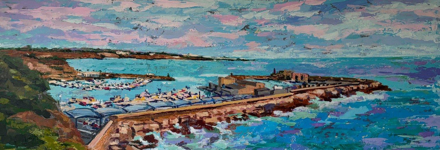 Puerto con embarcaciones y lonja. La escollera. Al fondo un pueblo blanco.