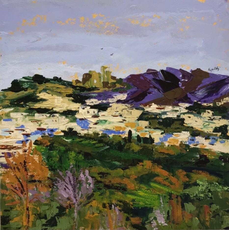 Pueblo blanco andaluz con las montañas y el campo que lo integran en el paisaje. Un cielo azul con tonos morados. Al fondo hay una peña sobre la que vuelan dos rapaces.